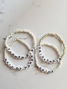 three bracelets with words on them sitting on a marble counter top next to each other