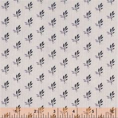 a white fabric with black leaves on it and a ruler in front of the image