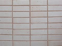 a white tiled wall with brown spots on it