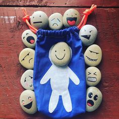 a blue bag filled with lots of rocks covered in faces