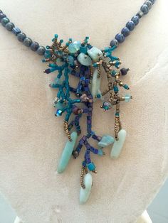 a necklace made with beads and stones on a mannequin