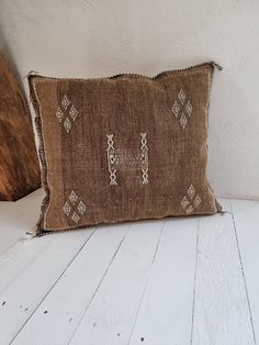 a brown pillow sitting on top of a white wooden floor