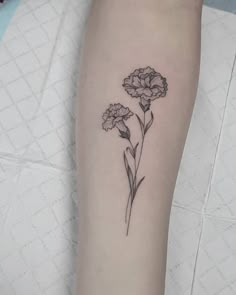 a black and white flower tattoo on the left arm, with two flowers in it