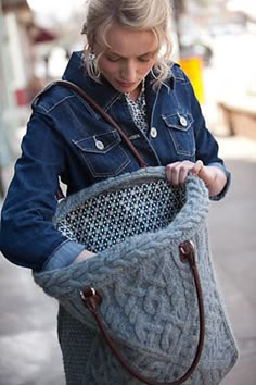 a woman is holding a bag on the street