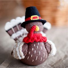 a small crocheted turkey with a hat and scarf on it's head