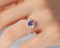 a woman's hand with a diamond and blue sapphire ring