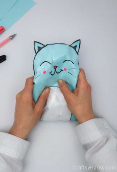 a person is holding a cat shaped pillow