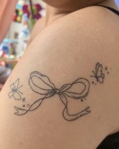 a woman with a tattoo on her shoulder that has a bow and butterflies drawn on it