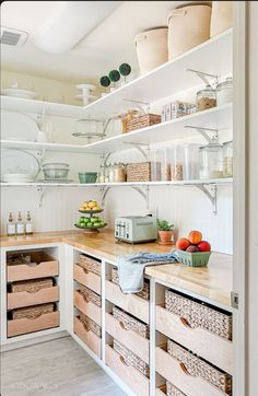 a kitchen with lots of shelves and baskets on top of it's counter tops