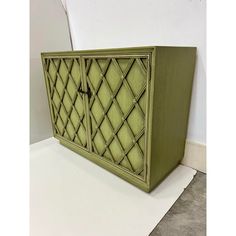 a green cabinet sitting on top of a white floor