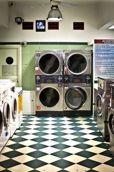 a row of washers and dryers in a room with checkered flooring