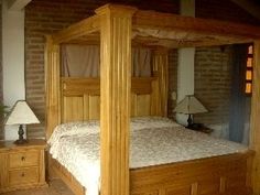 a bedroom with a four poster bed and two night stands