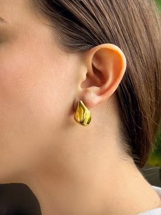 This 18K gold plated earring is a striking piece of jewelry, its elegance derived from its irregular drop form. Crafted with meticulous detail, it embodies a sense of organic beauty that captivates the eye. Gold Teardrop Plug Earrings For Everyday, Everyday Gold Teardrop Plug Earrings, Gold Tarnish Resistant Drop Huggie Earrings, Gold Hypoallergenic Teardrop Plug Earrings, Classic Teardrop Gold Plated Earrings, Gold Plated Clip-on Earrings With Polished Finish, Gold Drop Huggie Earrings Hypoallergenic, Classic Gold-plated Teardrop Earrings, Gold Tarnish Resistant Drop Earrings