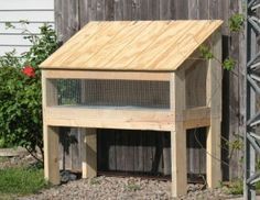 a wooden structure with a bird house on it's side in front of a fence