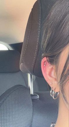 a woman with ear piercings in the back seat of a car