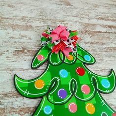 a green christmas tree shaped ornament with a bow on it's head