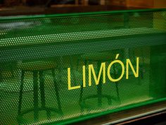 a green bench with the word limoon written on it and two stools behind it