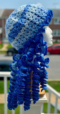 a crocheted blue hat and scarf on top of a mannequin's head