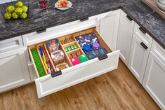 an open drawer in the middle of a kitchen