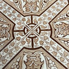 an intricately designed tile is shown in brown and white