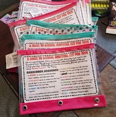 a pile of papers sitting on top of a wooden table next to a bag filled with candy