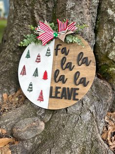 a wooden sign that says fa la la la leave hanging on a tree