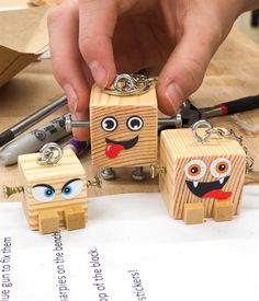 someone is making wooden key chains out of wood blocks with eyes and mouths on them