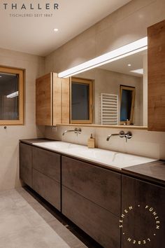 a bathroom with two sinks and mirrors in it