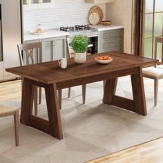 a wooden table sitting in the middle of a kitchen next to a white counter top oven