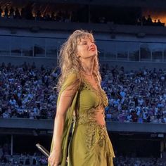 a woman in a green dress on stage