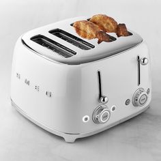 a toaster with two pieces of bread on it sitting on a white counter top