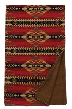 a red and black rug with a brown blanket on it's side, next to an area rug