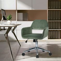 a green office chair sitting in front of a computer desk