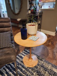 a small table with a potted plant sitting on it's top next to a chair