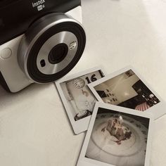 three polaroid pictures sitting on top of a table next to a camera