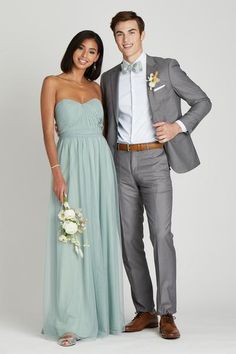 a man and woman in formal wear standing next to each other, posing for the camera