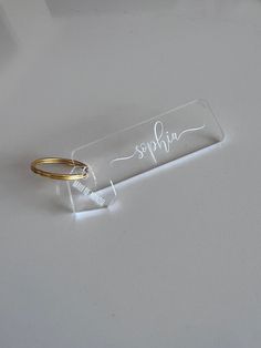 a pair of gold rings sitting on top of a white table next to a sign