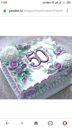 the cake is decorated with purple flowers and green leaves on it's side, which reads 50