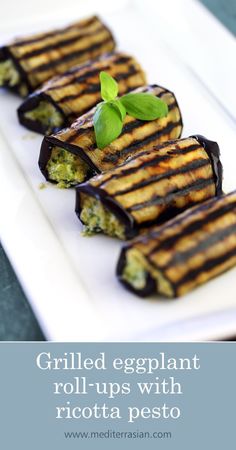 grilled eggplant roll - ups with ricotta pesto on a white plate