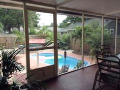 a screened in porch with a pool and patio furniture