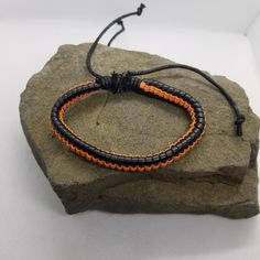 If you like orange and black, then this simple bracelet is perfect for you to add to your collection. The bracelet is adjustable via a sliding knot. Product Information Material: PU leather Clasp Type: rope (sliding knot) Adjustable: 6.5 inches to 8 inches Handmade Black Braided Casual Bracelet, Handmade Black Casual Braided Bracelet, Casual Black Handmade Braided Bracelets, Casual Black Handmade Braided Bracelet, Handmade Black Wristband For Friendship, Casual Black Beaded Bracelets For Friendship, Handmade Black Bracelets With Waxed Cord, Black Beaded Bangle Bracelets For Friendship, Black Beaded Friendship Bangle Bracelet