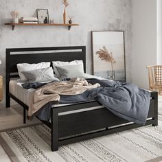 a bed sitting on top of a wooden floor next to a wall with pictures above it