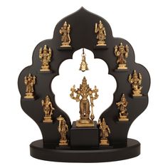 an assortment of gold and black figurines sitting on top of a stand in front of a white background