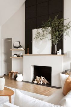 a living room filled with furniture and a fire place in front of a white fireplace