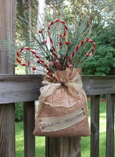 a bag filled with candy canes sitting on top of a wooden fence