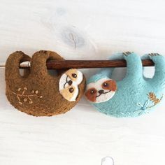 two stuffed animals are hanging on a wooden stick with one slotty and the other slotty