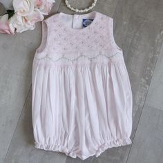 This Adorable Baby Girl's Romper In Size 9 Months Is Precious! Perfect For Spring And Summer! Made Of A Cotton Blend For Easy Care In A Sweet Pale Pink Hue. The Entire Front Bodice Is Done In A Lattice Smocking With Adorable Little Floral Bullion Rosebuds Evenly Spaced Throughout The Lattice Design. Just Above The Waist Sits An Accordion Row Of Smocking With A Pink And White Embroidered Border. A Pink, White And Green Floral Vine Is Embroidered Across The Accordion Smocking. Matching Piping Trim Cute Pink Bubble Romper With Smocked Back, Cute Pink Bubble Romper With Smocked Bodice, Sleeveless Bubble Romper With Smocked Back For Spring, Spring Sleeveless Bubble Romper With Smocked Back, Pink Bubble Romper With Smocked Back For Summer, Fitted Pink Bubble Romper For Baptism, Lattice Smocking, Month Embroidery, Smocked Romper