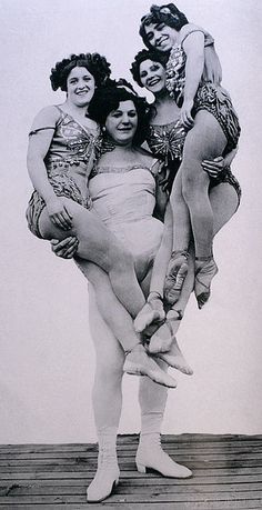 four women in bathing suits are posing on a dock with their arms around each other