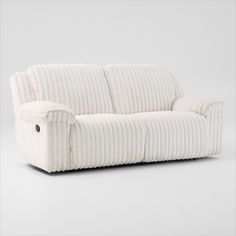 a white corded couch with buttons on the armrests and back cushions, in front of a gray background