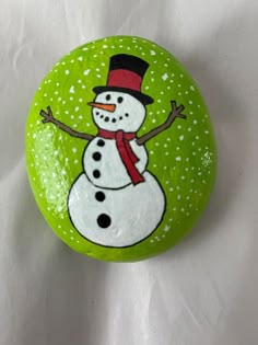 a painted rock with a snowman on it